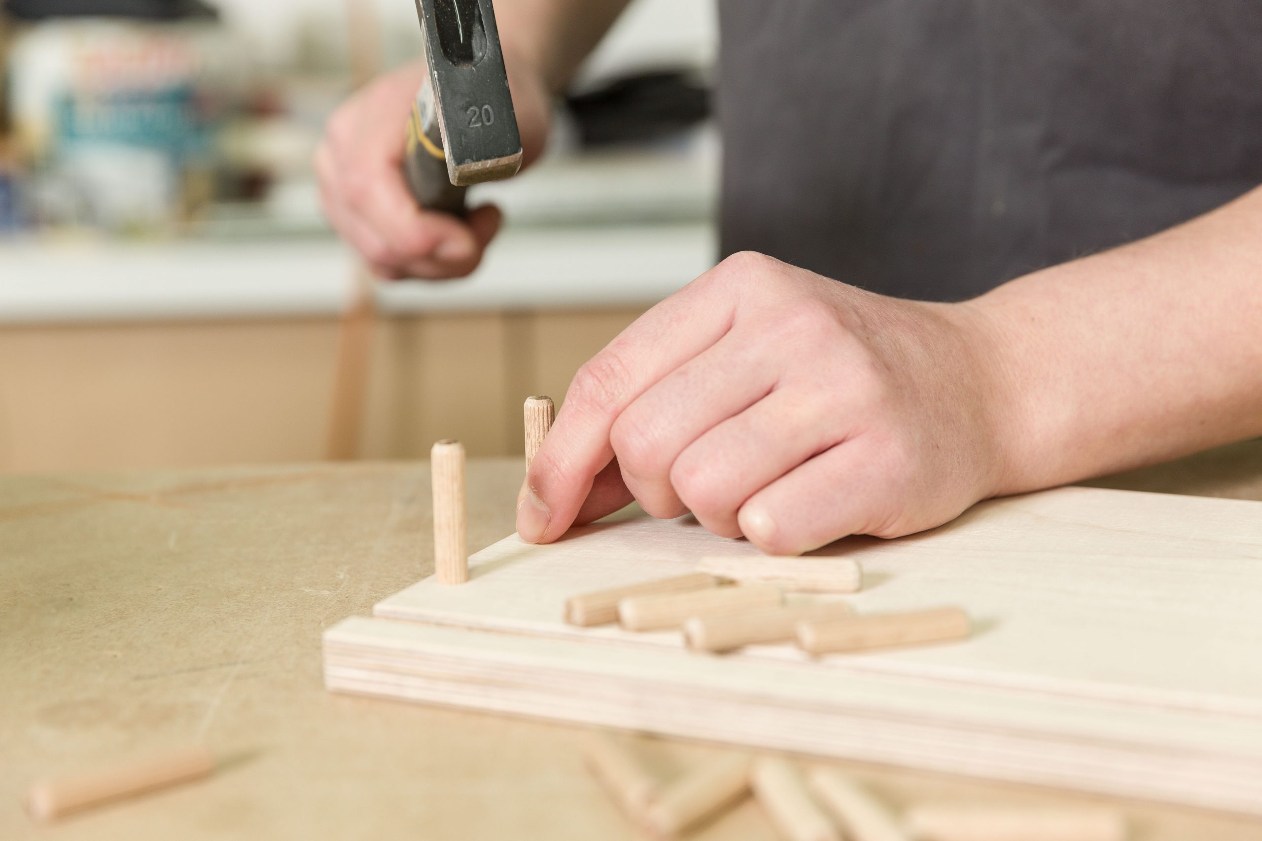 Holzdübel werden in ein Brett eingeschlagen